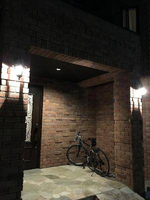 レンガ造りの玄関に煌々と灯る玄関ライト