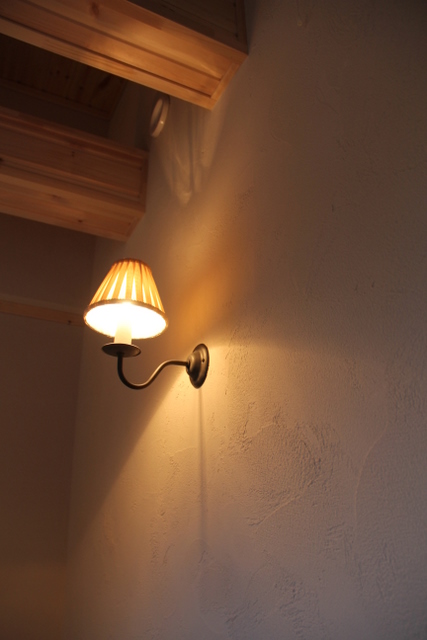 ログハウス風の邸宅の階段に、ロウソク型ブラケット照明－塗り壁なので、アンティーク風が良く似合う　F03邸