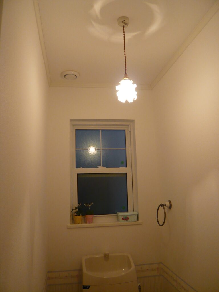 バラの形のガラスシェードを使ったペンダントライトを、漆喰壁のいつまでも飽きのこないトイレの照明として　M21邸
