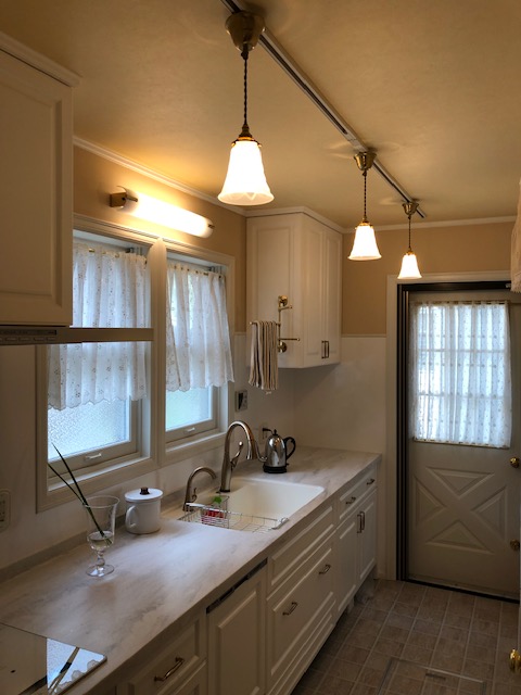 プロヴァンス風の壁付けキッチンに3つのペンダントライトが穏やかな灯りを